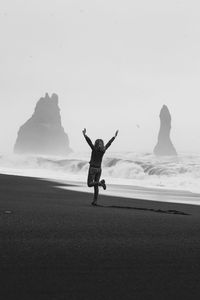 Excited tourist on empty black beach monochrome scenic photography