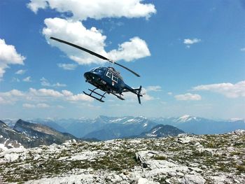 Overhead cable car over mountains against sky