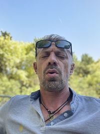 Portrait of man wearing sunglasses against sky