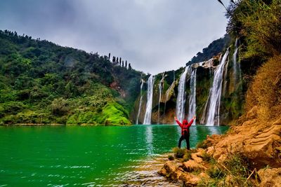 Scenic view of waterfall against sky