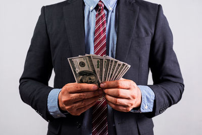 Midsection of businessman holding heart shape against white background