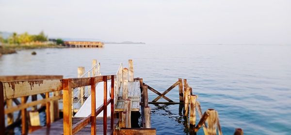 Wooden pier over sea against sky