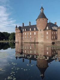Reflection of building on lake against sky