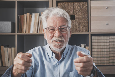 Portrait of senior man with hand with face