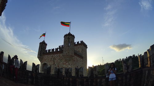 Low angle view of flag on built structure against sky