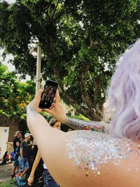 Rear view of woman photographing with mobile phone