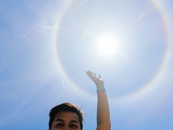 Low angle view of woman against sky at sunny day