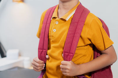 Midsection of woman standing against wall