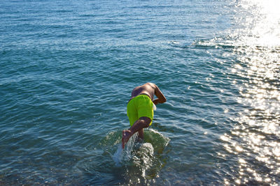 Rear view of boy standing in sea