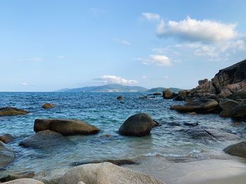 Rocks on sea shore against sky