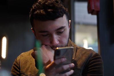 Young man using mobile phone at home