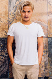 Portrait of teenage girl standing against wall