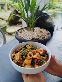 High angle view of hand holding food on table