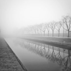 Scenic view of lake against sky during foggy weather