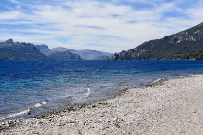 Scenic view of sea and mountains against sky