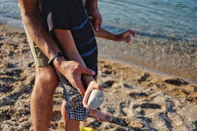 Low section of man walking on beach
