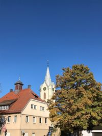 Trees and buildings against blue sky