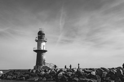 Lighthouse by sea against sky