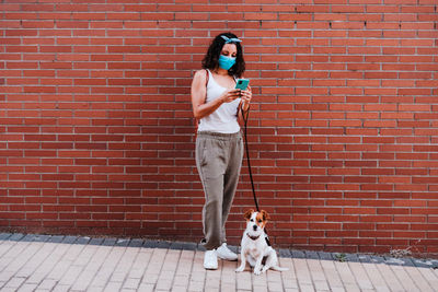 View of a dog standing against brick wall