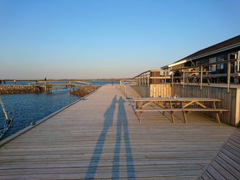 High angle view of man and woman shadow on pier by sea