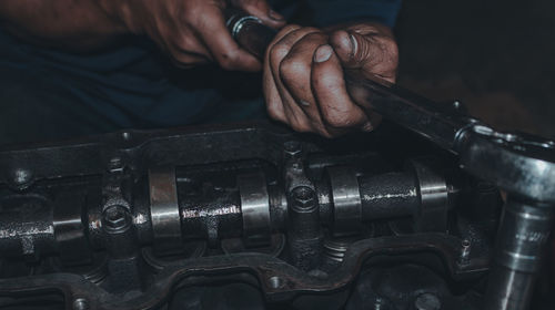 Close-up of man repairing motorcycle