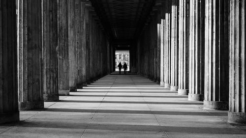 Rear view of people walking in corridor of building