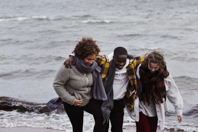 Group of friends walking along sea