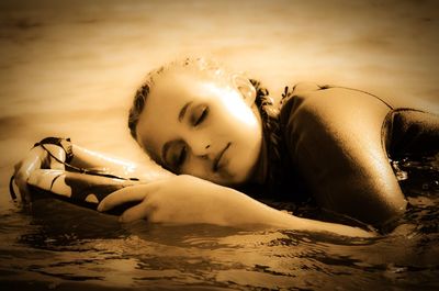 Portrait of young woman lying on shore