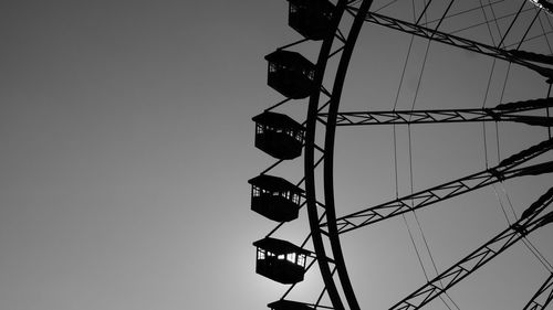 Low angle view of silhouette ferris wheel against sky