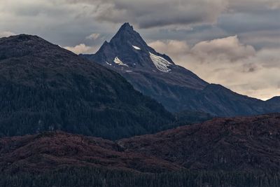 Scenic view of mountains against cloudy sky