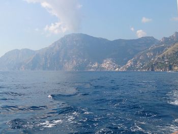 Scenic view of sea and mountains against sky