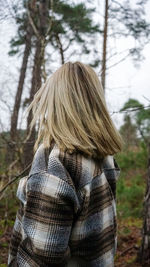 Rear view of woman standing in forest