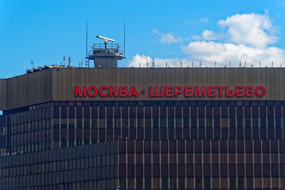 Information sign on building against sky