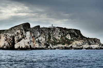 Rock formations by sea against sky