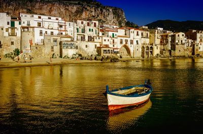 Boats moored in canal by buildings in city