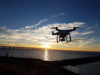 Drone flying over beach during sunset