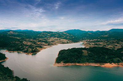 Scenic view of river and mountains against sky