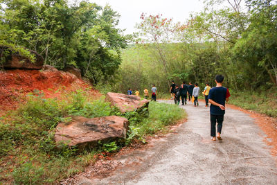 Rear view of people walking on footpath