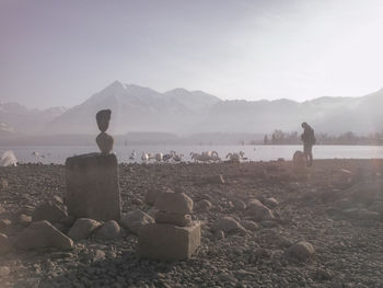 Rear view of people on rock against sky