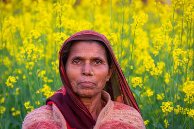 Portrait of woman against yellow flowering plants