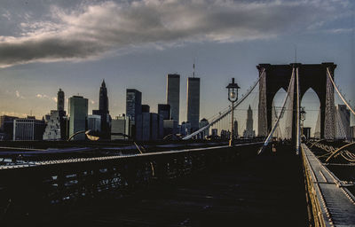 View of suspension bridge and buildings against sky