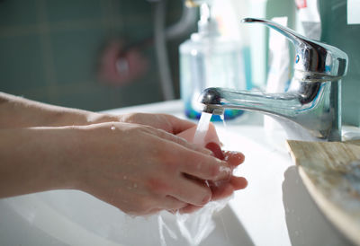 Cropped image of person washing hands