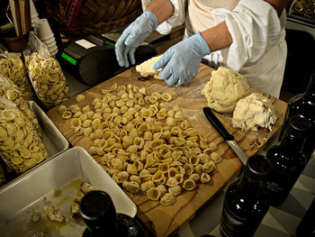 Midsection of man making pasta in kitchen