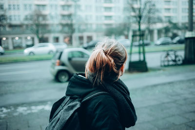 Side view of woman with backpack in city