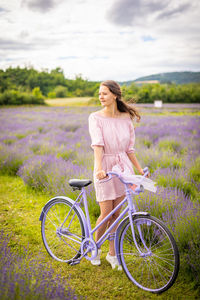 Woman with bicycle on field