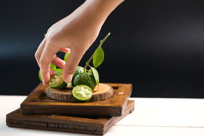 Close-up of hand holding ice cream on cutting board