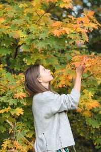 Woman standing by plants during autumn