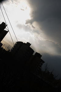 Low angle view of silhouette building against sky