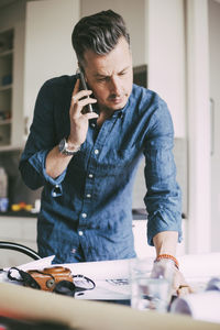 Man in office at home talking in telephone