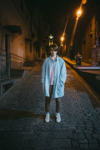 Full length of man standing on street at night